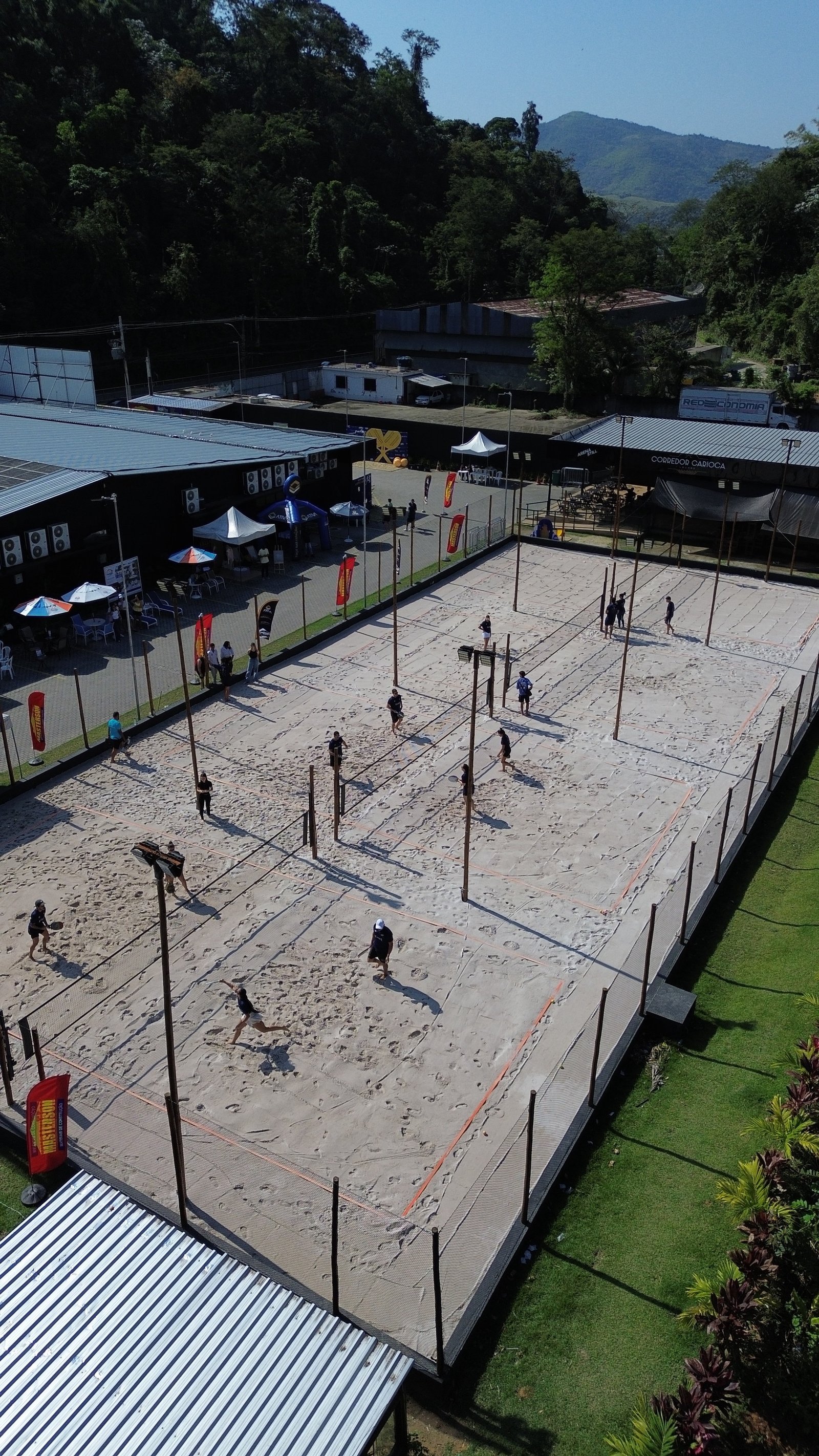 Quadra de areia da Still Fit Xerém vista de cima, com alunos jogando